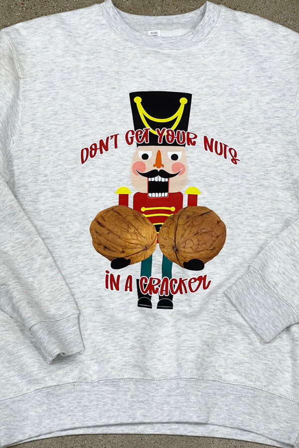 A gray sweatshirt with a graphic of a nutcracker and the text 'DON'T GET YOUR NUTS IN A CRACKER' on the front.